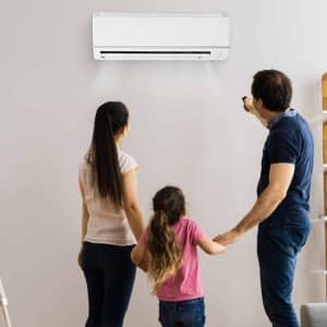 AC mistake #3: Concerned family near their mini-split air conditioner, noticing strange noises or odors – critical AC warning signs.