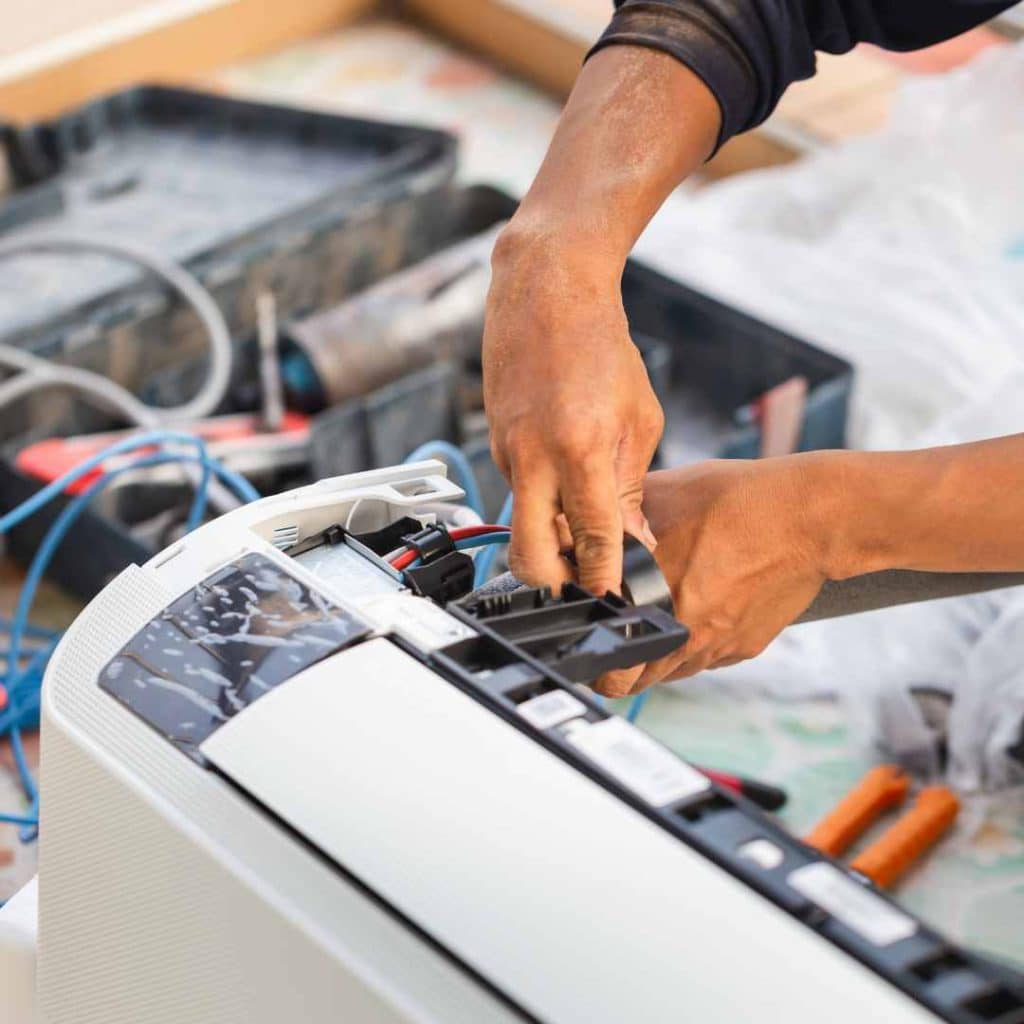 Detailed AC maintenance by Richard's AC & Appliance Repair: Technician carefully inspects internal components of a mini-split unit, catching small problems early to avoid costly repairs.